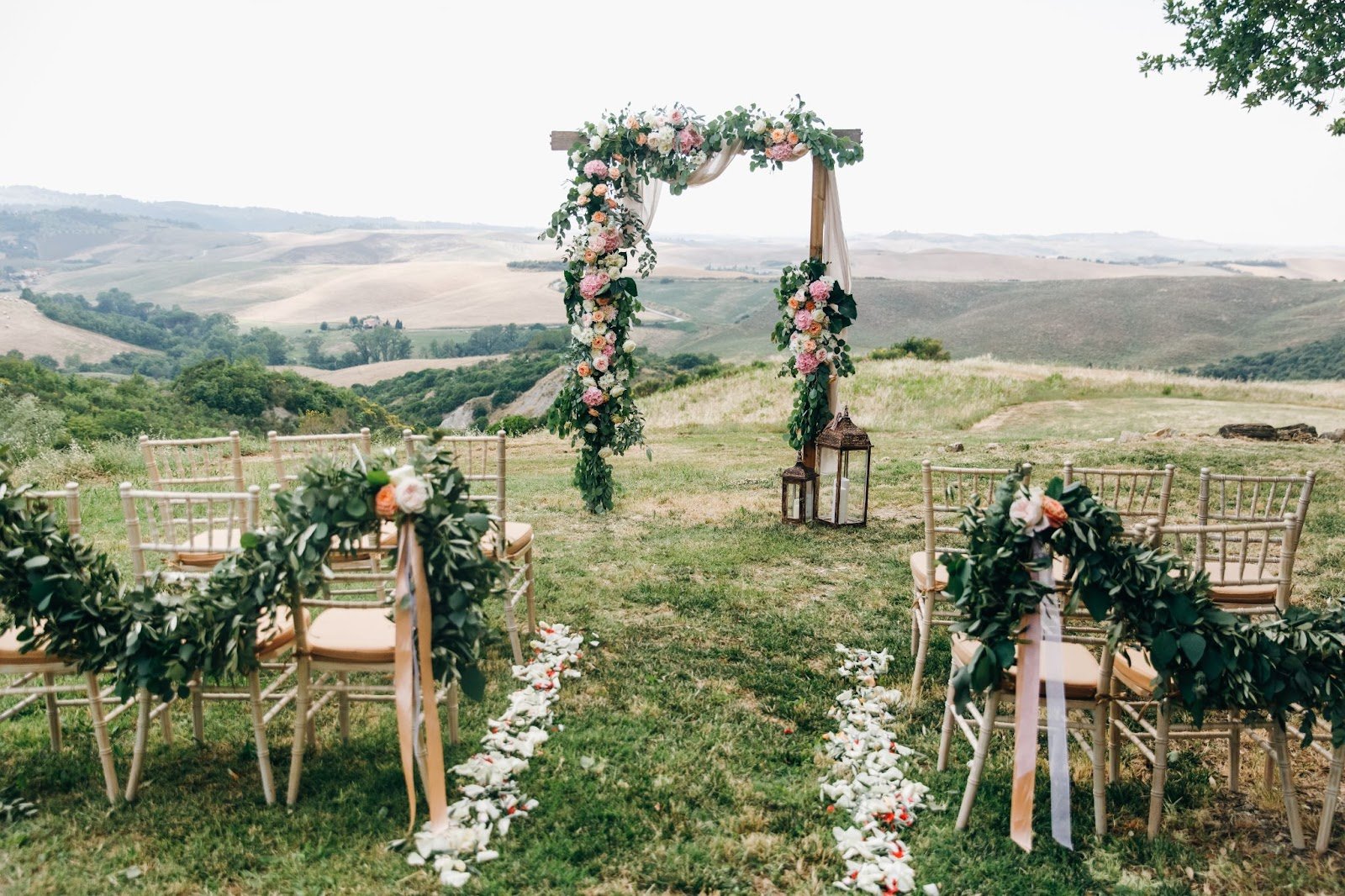 Rustic New Jersey wedding decoration with a floral arch and greenery-adorned chairs in an outdoor setting