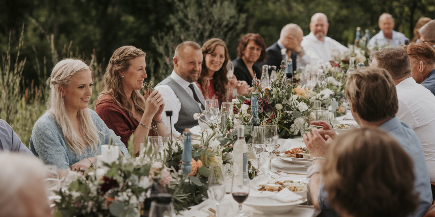 Guests enjoying a rustic outdoor wedding reception with a beautifully decorated table.