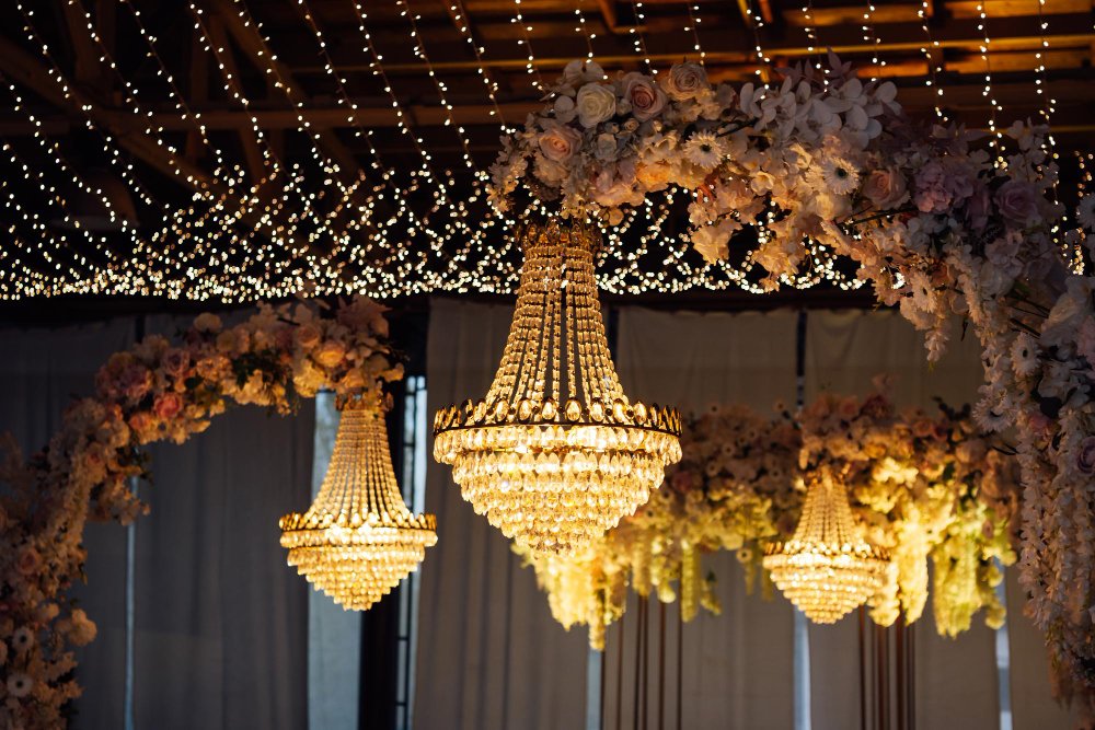 Classy indoor wedding ceremony styling with white and gold details and crystal chandeliers