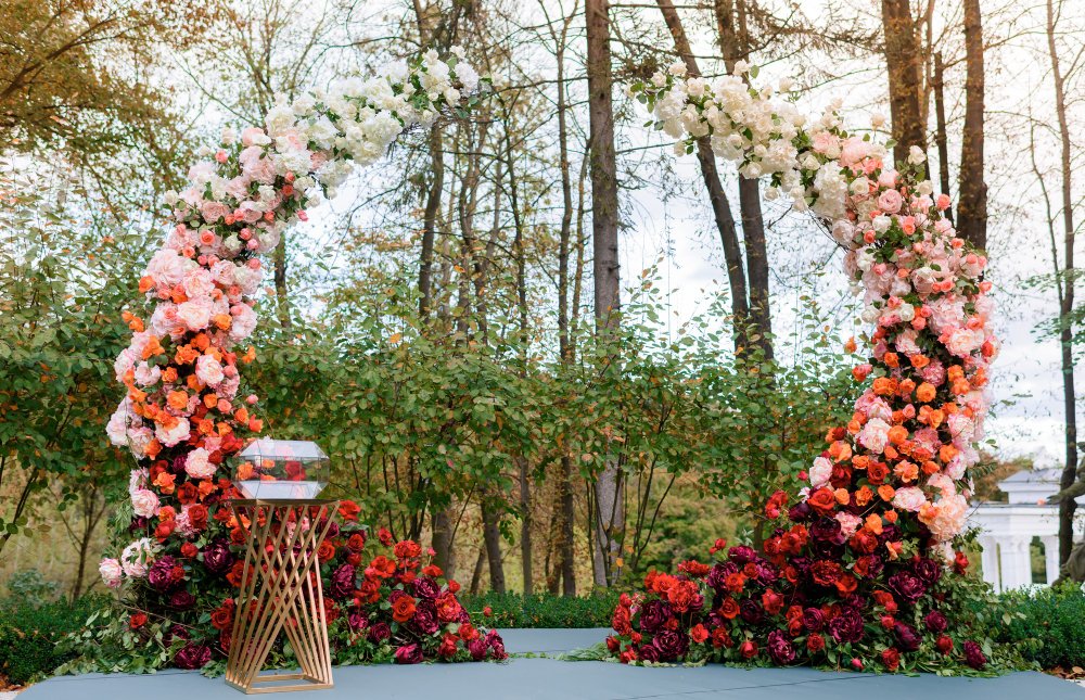 Romantic indoor wedding arch decoration with roses and orchids.
