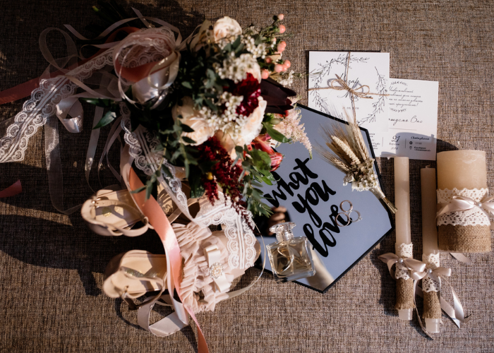 Outdoor ceremony decorated with greenery, soft pastel drapes, and floral arrangements in dusty rose and dusty blue tones.