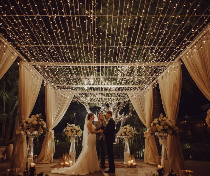 Canopy of string lights for outdoor wedding reception décor.